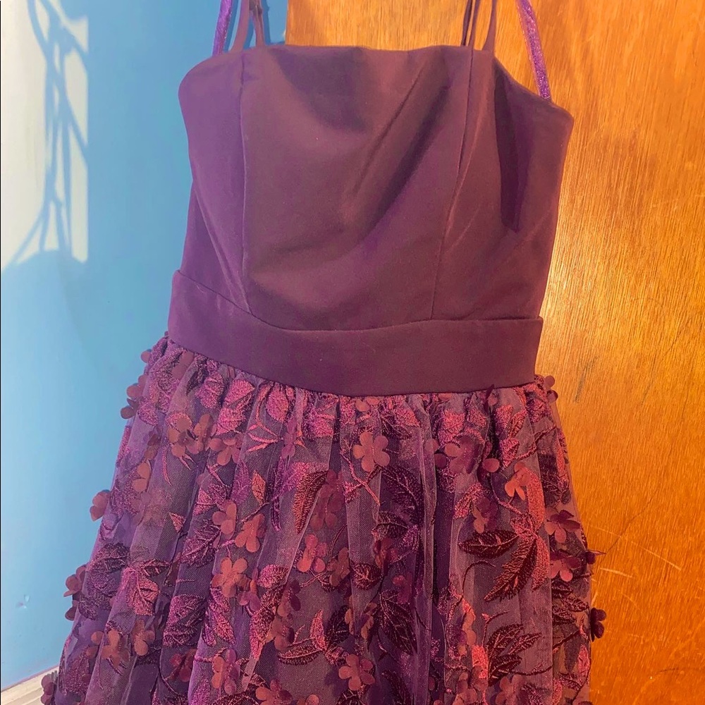 Plum colored homecoming dress with flowers and leaves on the skirt